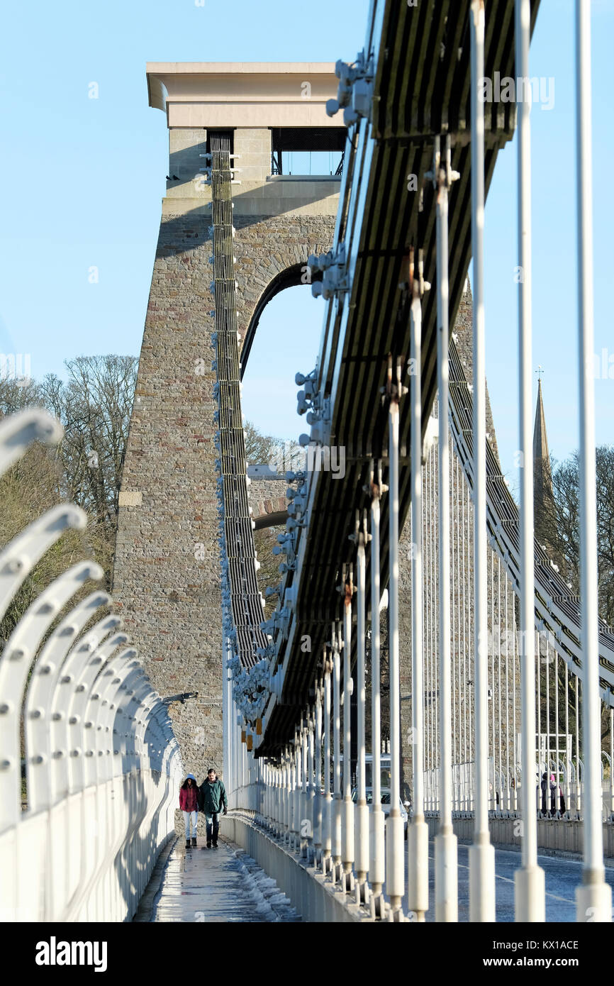 Un couple, homme et femme, se tenant la main. prendre une rapide promenade d'hiver à travers le pont suspendu de Clifton, Bristol.Ses une froide journée d'hiver ensoleillée, Banque D'Images