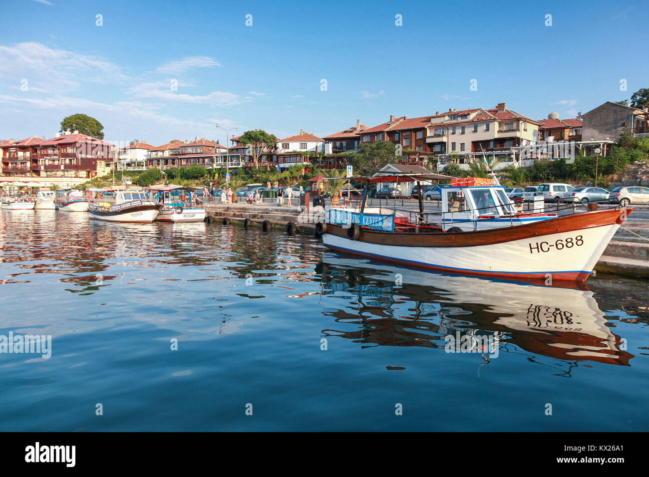 Nessebar, Bulgarie - 20 juillet 2014 : Plaisir bateau amarré dans le vieux port de Nessebar. Les gens ordinaires et les touristes à pied sur la rue côtière Banque D'Images