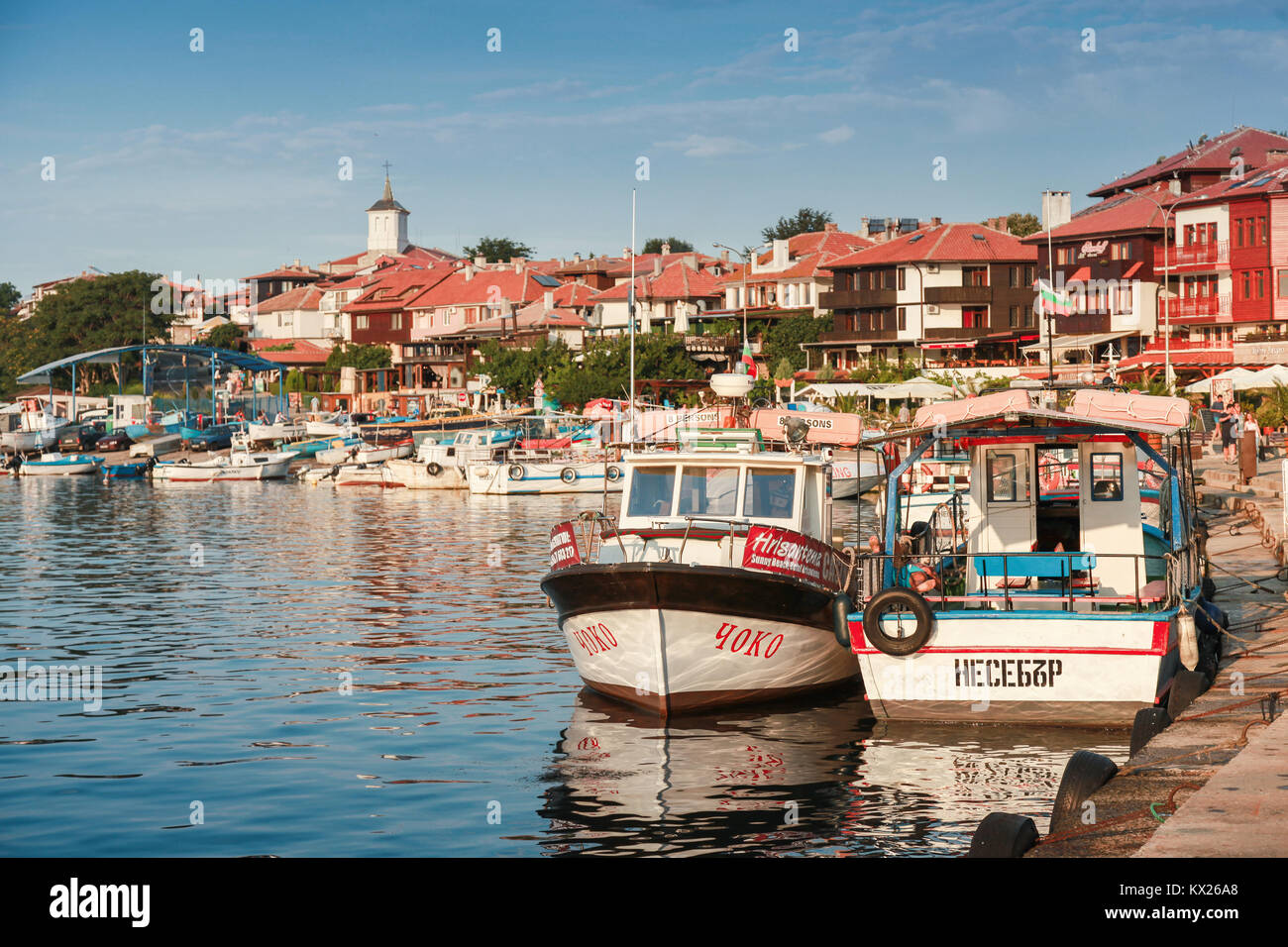 Nessebar, Bulgarie - 20 juillet 2014 : les bateaux de plaisance sont amarrés dans le vieux port de Nessebar. Les gens ordinaires et les touristes à pied sur la rue côtière Banque D'Images