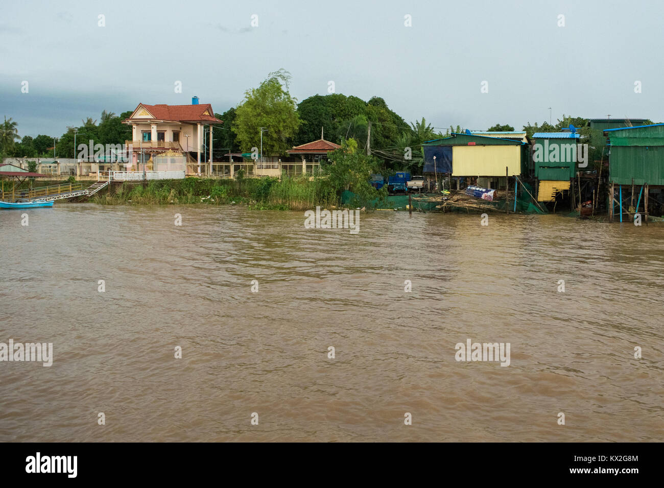 Riche d'une belle maison à côté d'un bidonville de taudis des cabanes en tôle ondulée sur la rive du fleuve du Mékong, près de Phnom Penh, Cambodge, Asie Banque D'Images