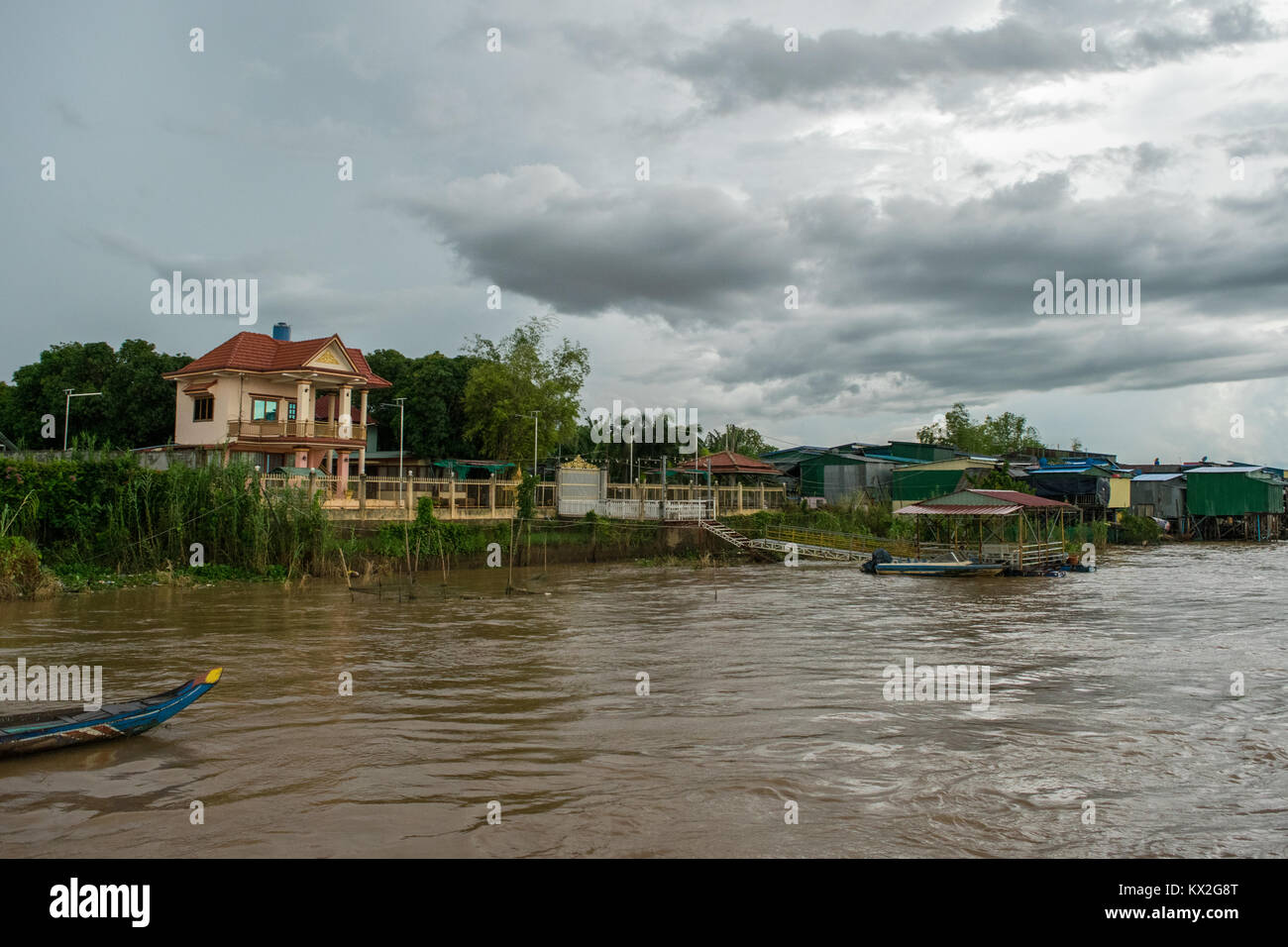 Riche d'une belle maison à côté d'un bidonville de taudis des cabanes en tôle ondulée sur la rive du fleuve du Mékong, près de Phnom Penh, Cambodge, Asie Banque D'Images