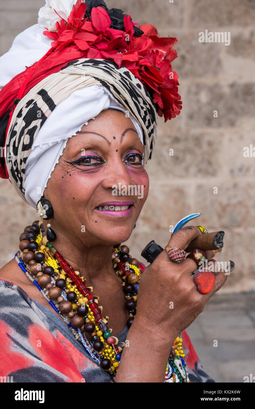 Portrait d'une vieille femme portant un costume et ornements typiques et fumer un cigare, dans la Plaza de la Catedral de La Habana, Cuba Banque D'Images