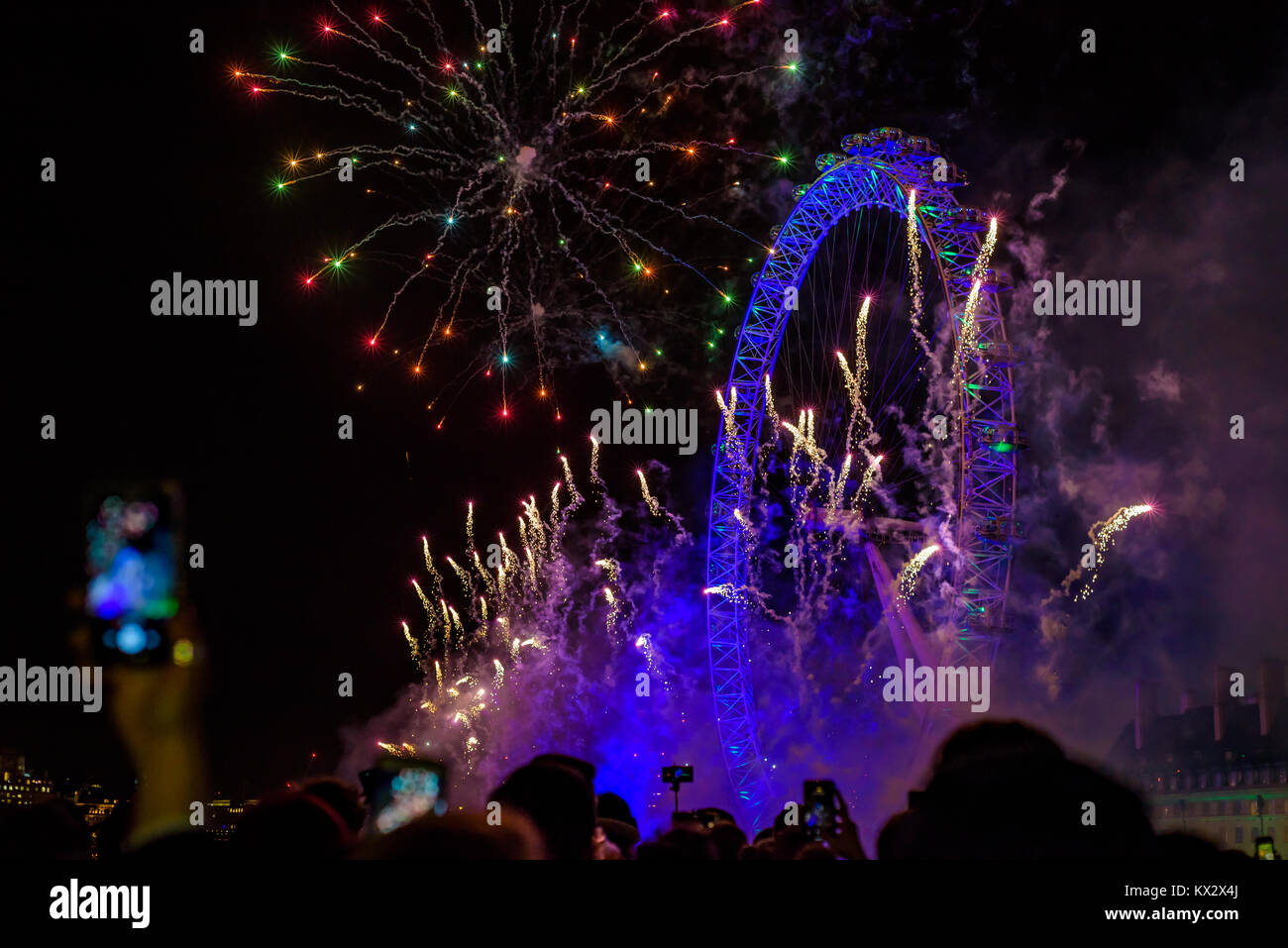 Londres, Royaume-Uni - 1er janvier 2018. Foule de gens regarder et enregistrer avec un téléphone mobile le feu d'artifice au London Eye pour marquer la fin de 2017. Banque D'Images