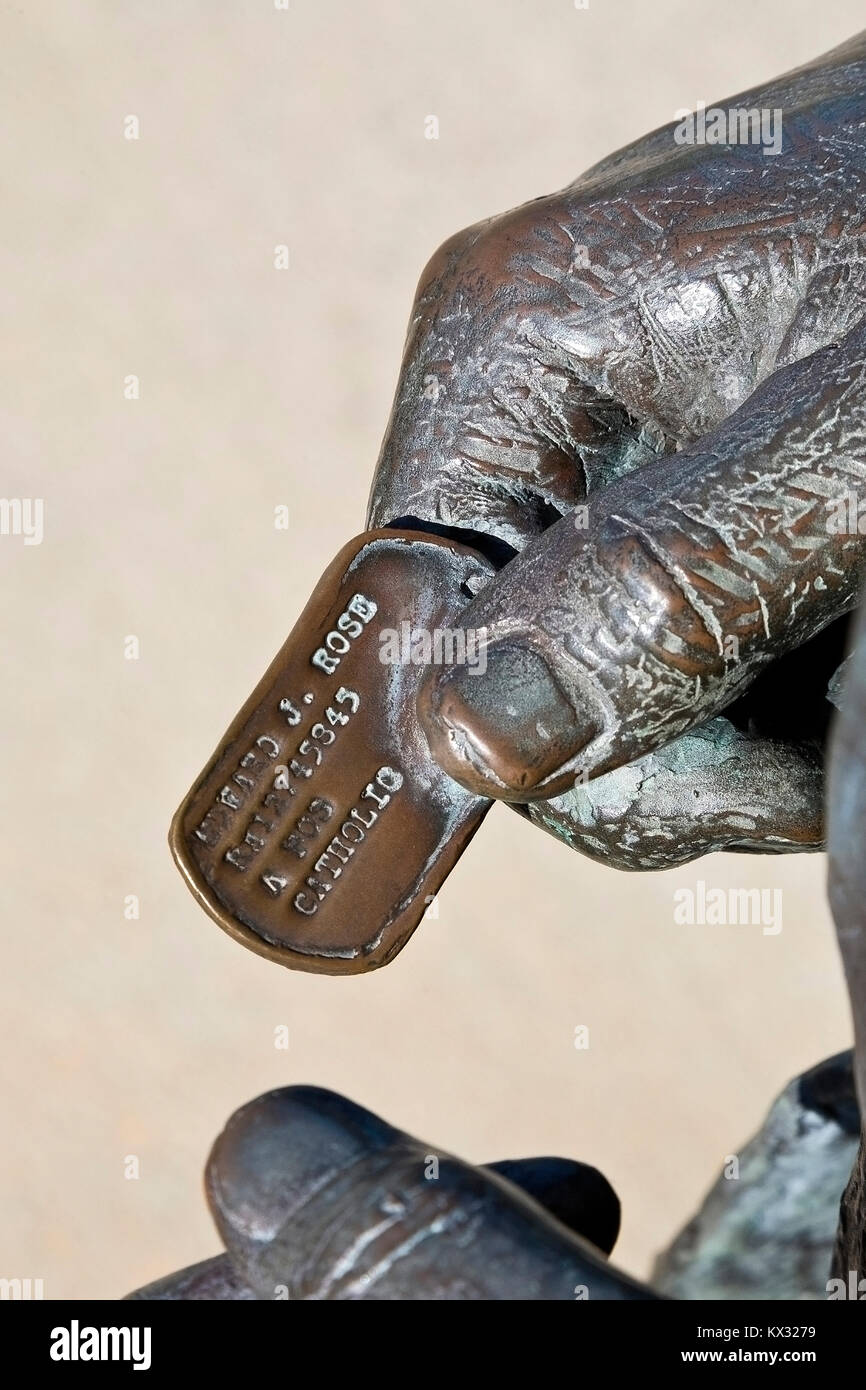 Statue dog tag militaire détenus par la main de personne. Vietnam Memorial, Mobile, Alabama. Mobile et Baldwin comtés, noms de 175 hommes sont sur le mur. Banque D'Images