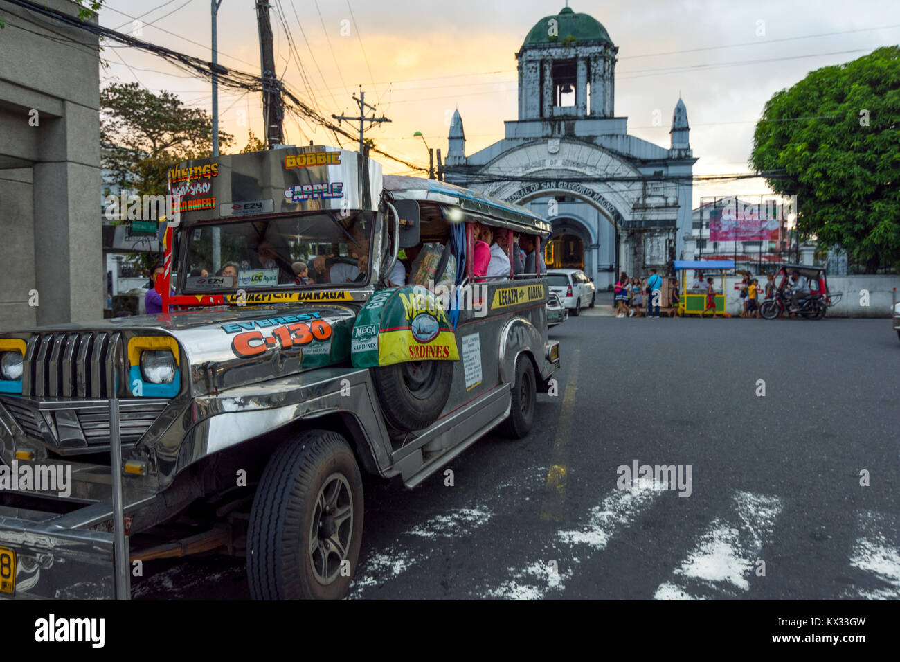 Transports publics Bus un Jeepney en attente d'un plus grand nombre de passagers à l'extérieur de la cathédrale de Saint Grégoire le Grand. Legazpi, aux Philippines. Banque D'Images