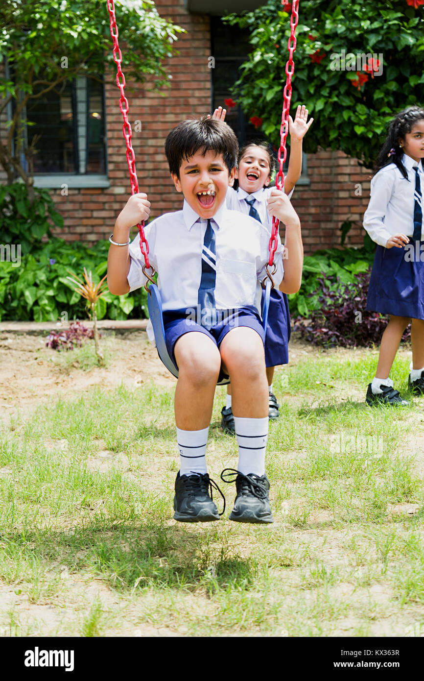 Les élèves de l'école indienne Swing Garçon Jhulla Having Fun In Park Banque D'Images