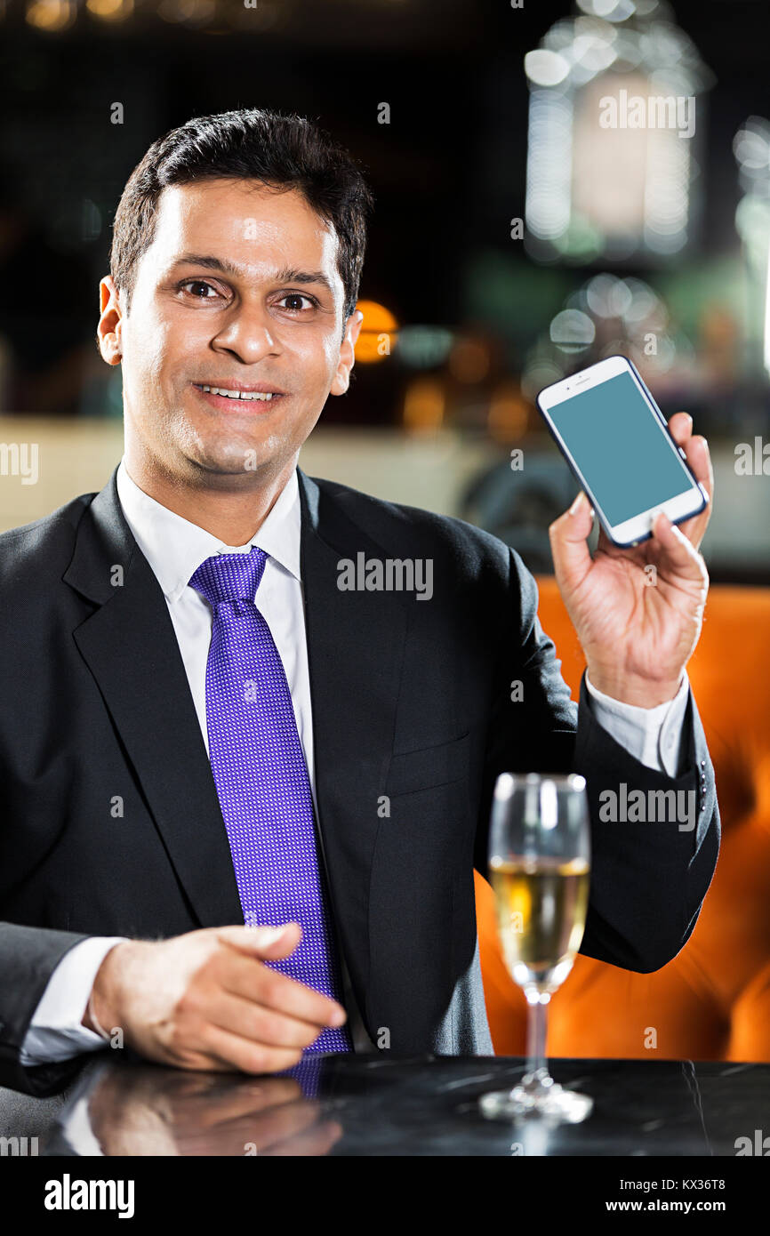 Un Business Man Sitting on Table In Restaurant Smartphone montrant Banque D'Images