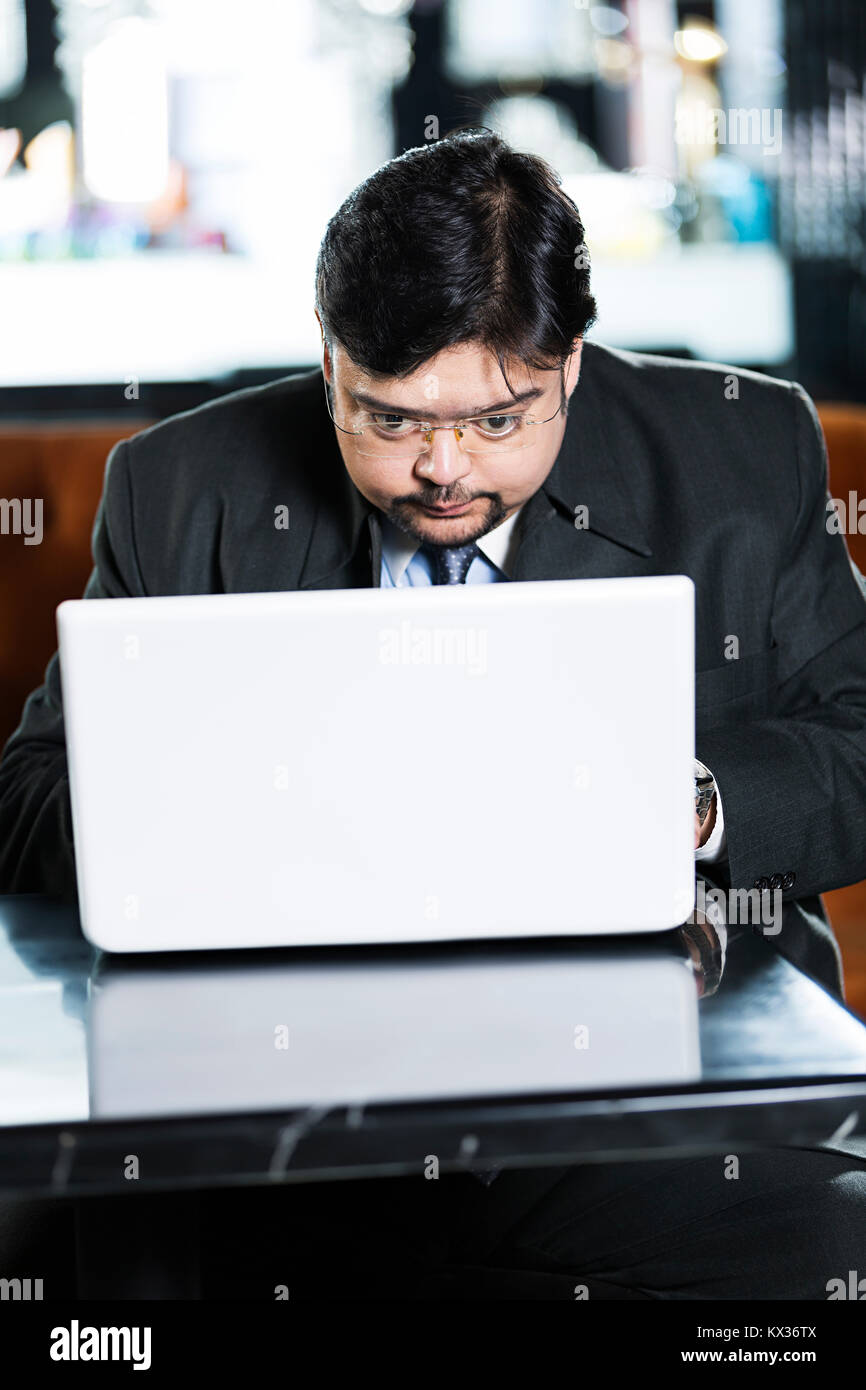 Un homme d'affaires graves travaille sur son laptop in office Banque D'Images