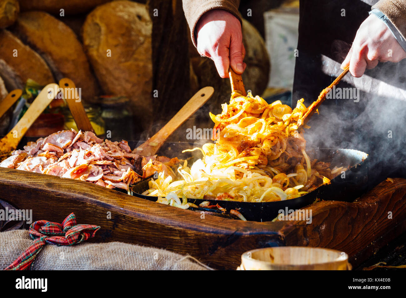 Marché de Noël de Cracovie qui sert de blocage de tranches de pain avec de la viande grillée, oignons et de la sauce. Banque D'Images