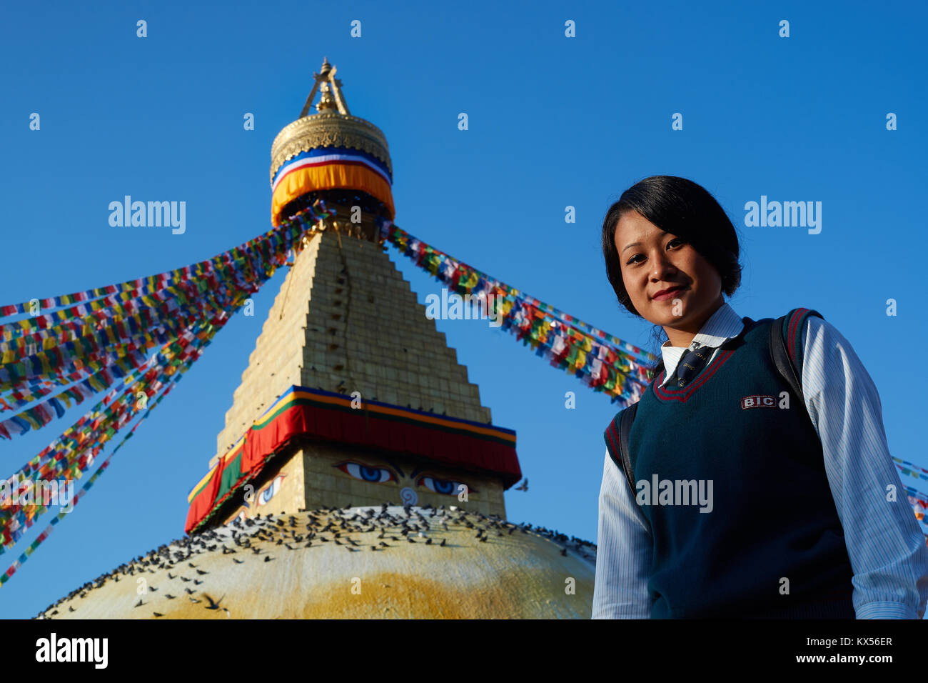 Nepali lycéenne posant devant le stupa bouddhiste de Boudhanath, Katmandou, Népal Banque D'Images