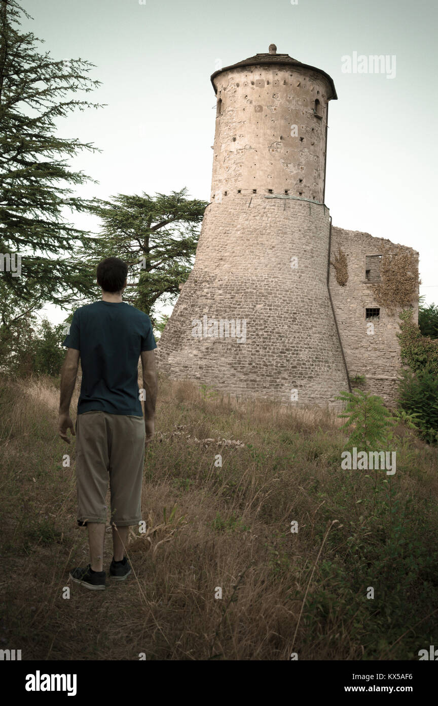 L'homme l'observation d'une vieille forteresse en face de lui, comme une sorte de défi. Château italien, placé en Émilie-Romagne. Banque D'Images