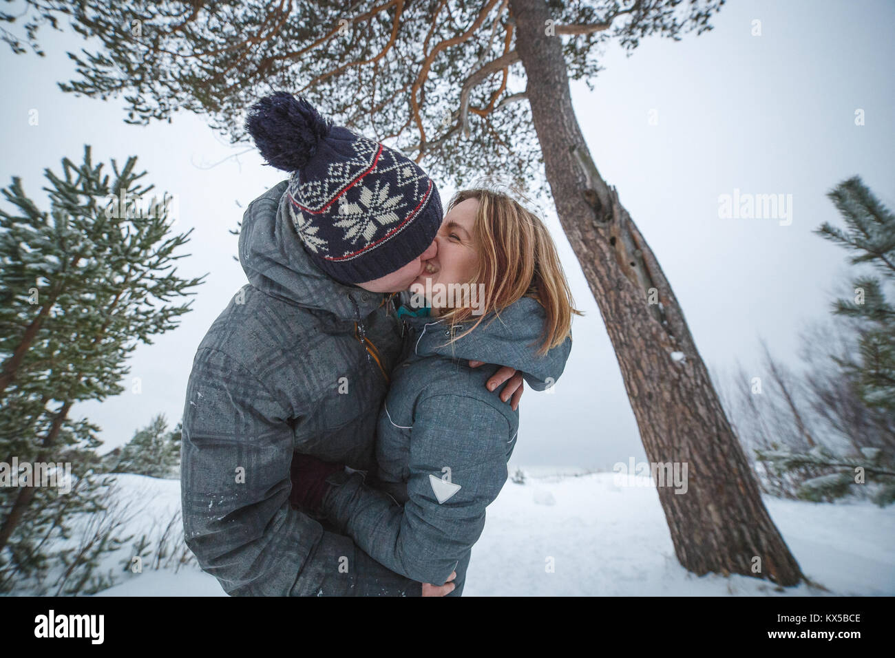 Jeune beau couple la pine tree in snowy winter forest Banque D'Images