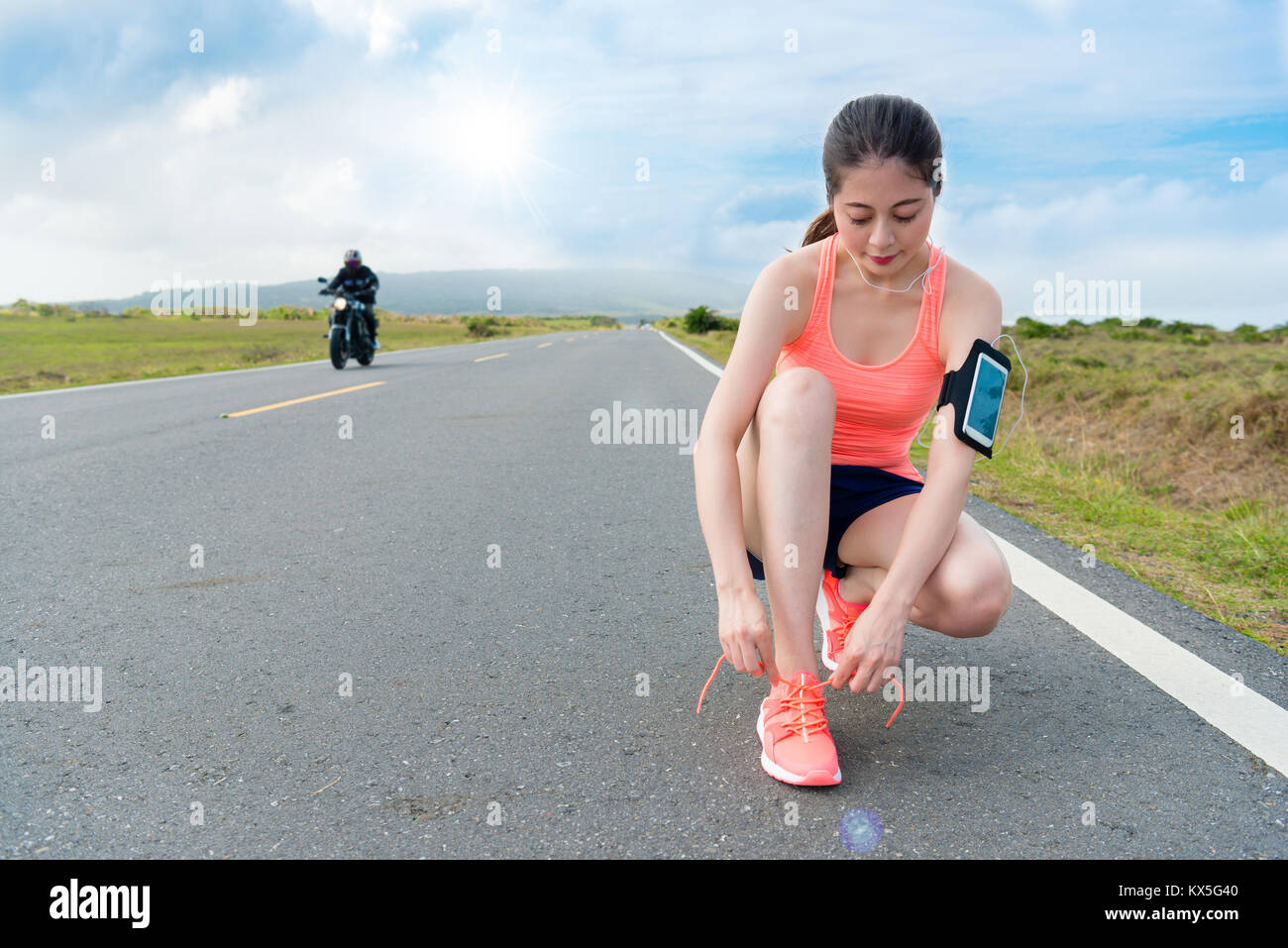 Beauty female jogger l'intention d'exécuter sur la route pendant les vacances d'été vacances et attaché les lacets prêt à la formation et d'entraînement. scooter Banque D'Images