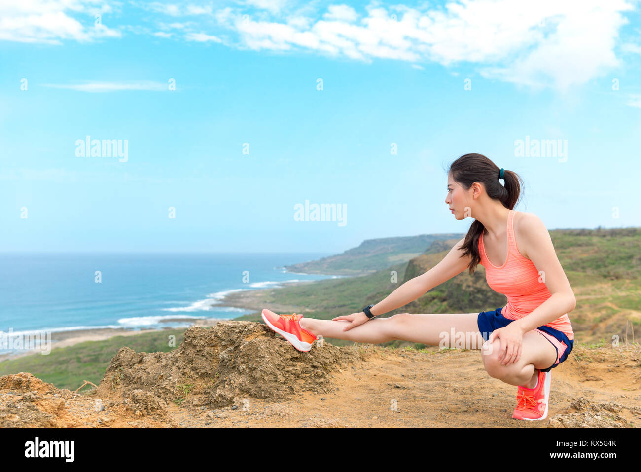 Belle jeune femme runner prêt à l'entraînement de la formation et de stretching leg réchauffer corps en montagne. Banque D'Images