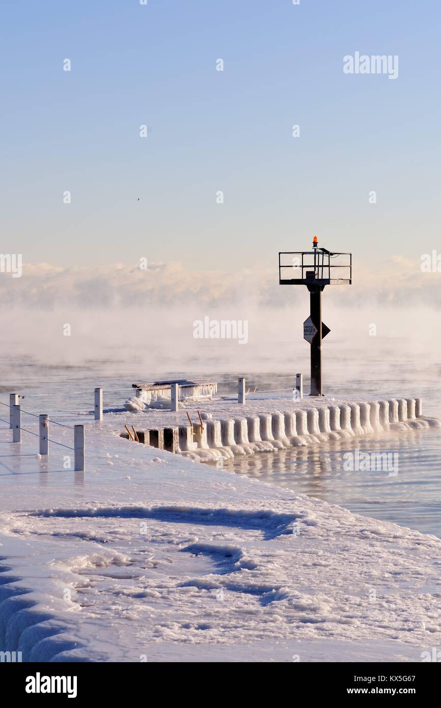 Couches de glace sur un brise-lames que de la vapeur s'élève des eaux du lac Michigan que la glace se forme dans le Chicago's 31st Street Port. Chicago, Illinois, USA. Banque D'Images