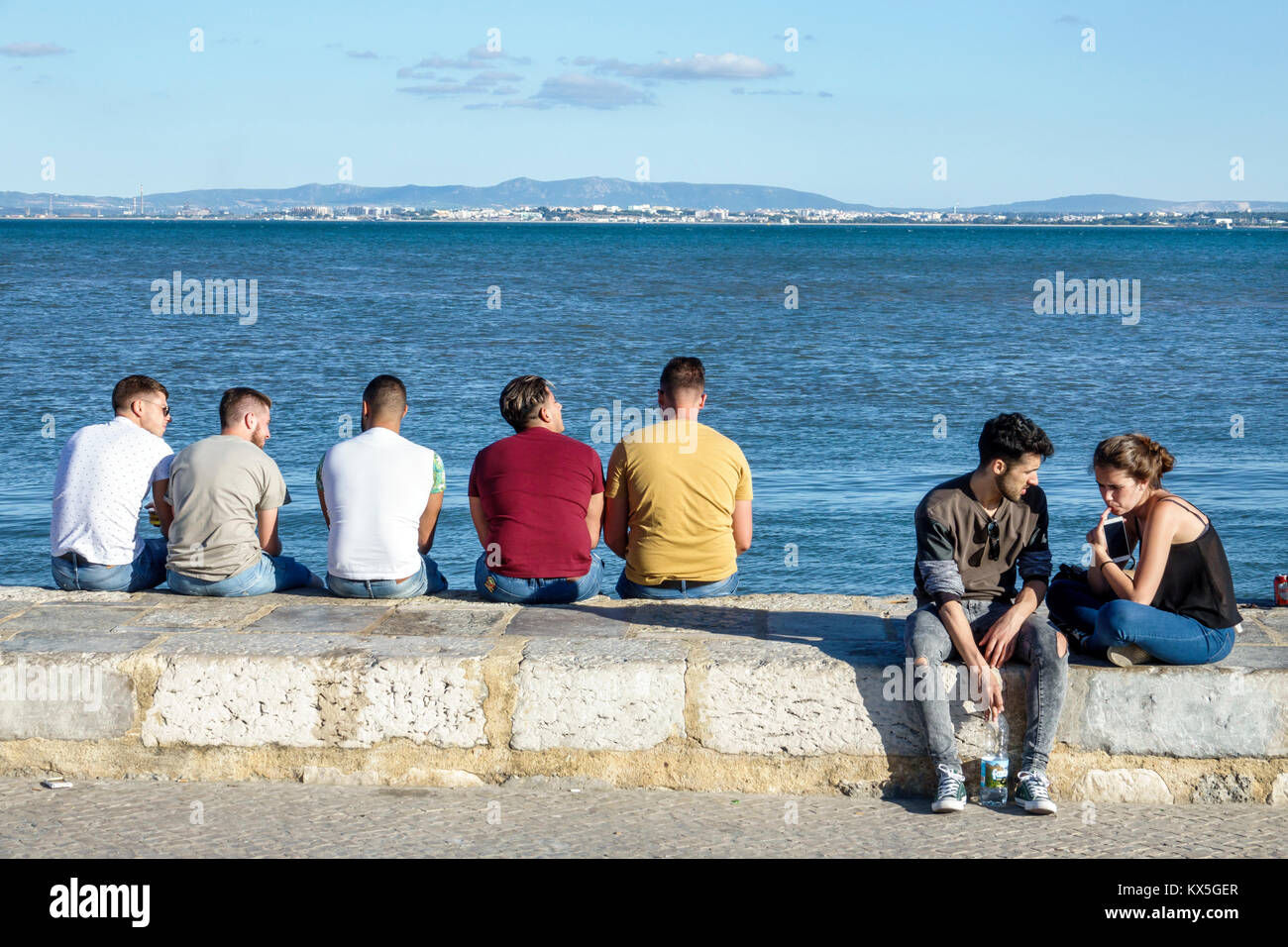 Lisbonne Portugal,Tage River,Cais do Sodre,front de mer,plaza,mur,hispanique,immigrants,homme hommes,femme femmes,couple,assis,hispanique, Banque D'Images