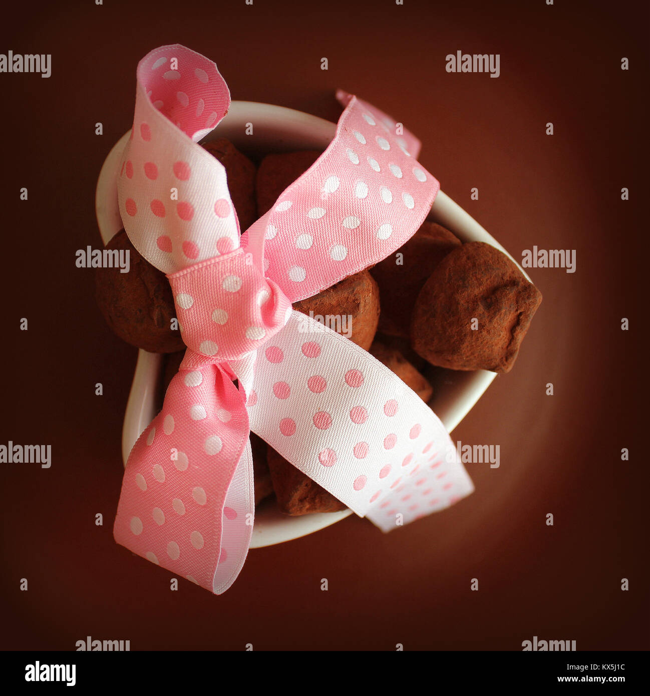 Truffes au chocolat gourmet pour la Saint-Valentin. Bonbons au chocolat servi sur un plat en forme de coeur et ruban décoratif Banque D'Images