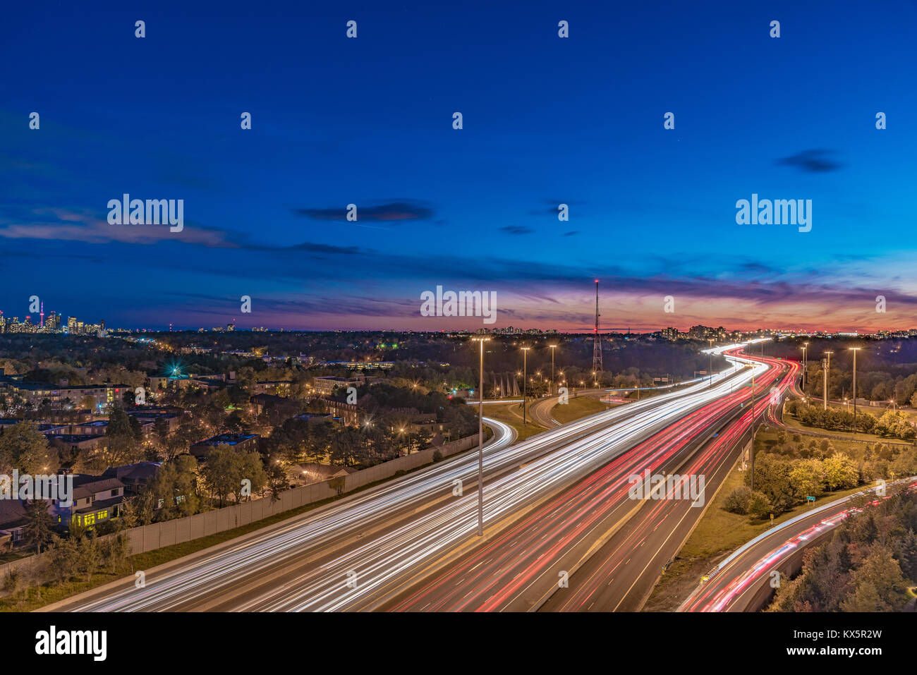 Photo de nuit de la route 401 à North York, Toronto, au cours de l'heure du crépuscule. Strie de lumière à partir de véhicules en mouvement Banque D'Images