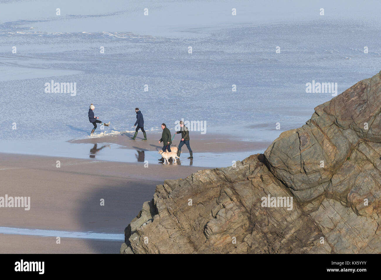 Une famille promènent leurs chiens à marée basse le long de Great Western Beach Newquay Cornwall. Banque D'Images