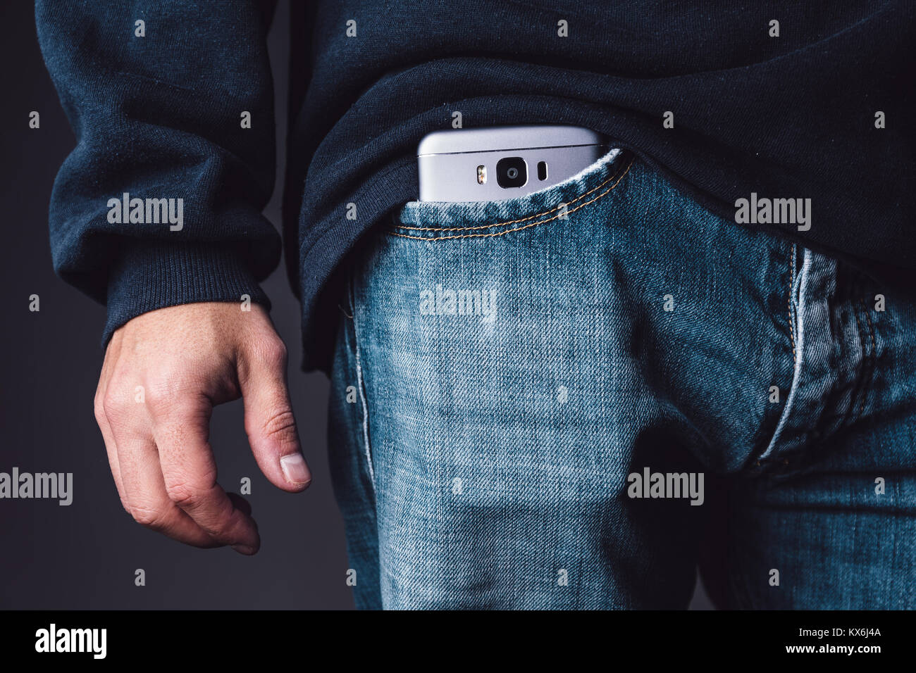 Smartphone sur un blanc poche de jean les jeunes adultes de sexe masculin. Banque D'Images