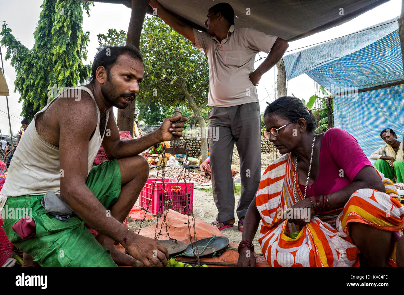 Un vendeur de légumes Légumes de pesage pour une dame d'acheteur, marché local dans le district de Dhanusha, au Népal Banque D'Images