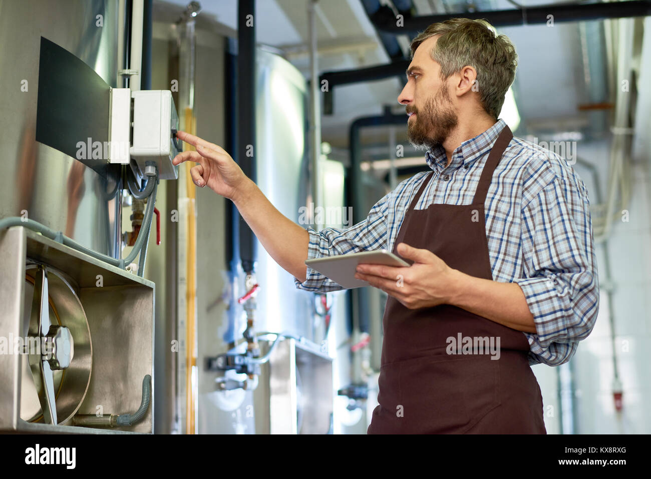Technicien barbu enveloppé dans le travail Banque D'Images