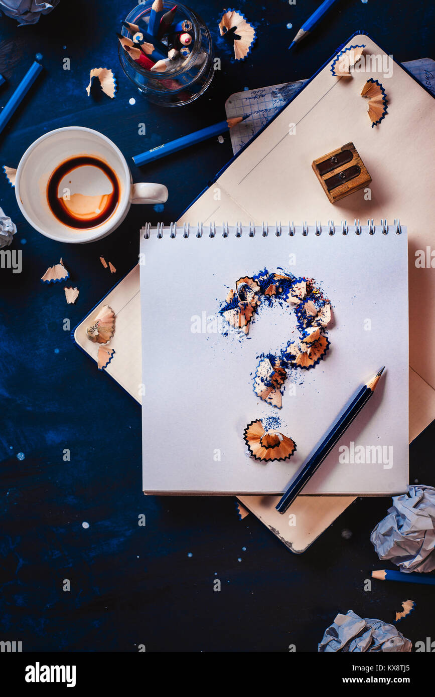 Point d'interrogation à partir de copeaux de crayon avec des boules de papier froissé, crayons, carnets et les tasses de café vide. La vie encore avec l'écrivain de travail. Bloc créatif Banque D'Images