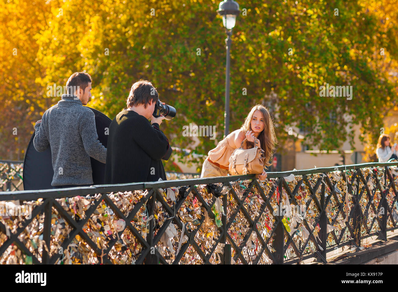 Paris fashion street, sur un matin d'automne un photographe et modèle d'entreprendre une analyse de la mode sur le Pont de l'Archeveche dans le centre de Paris, France. Banque D'Images