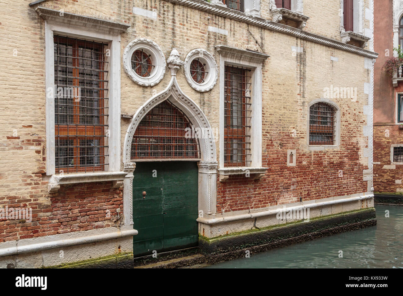 Porte et fenêtres à volets construction le long d'un petit canal en Vénétie, Venise, Italie, Europe. Banque D'Images