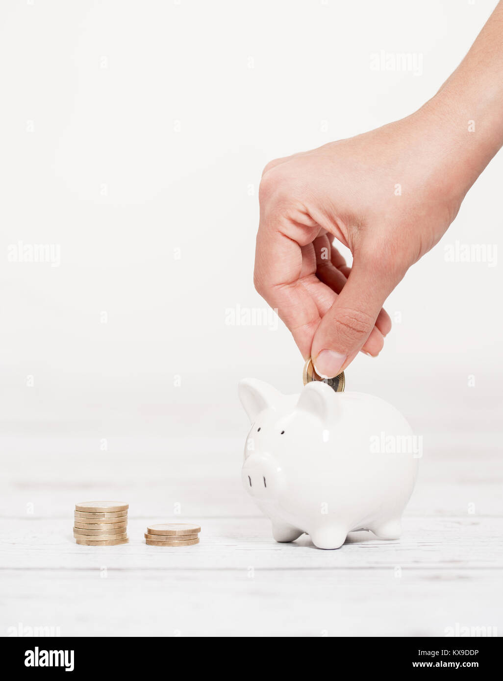 Tirelire et Coin de femmes sur le fond en bois blanc Banque D'Images