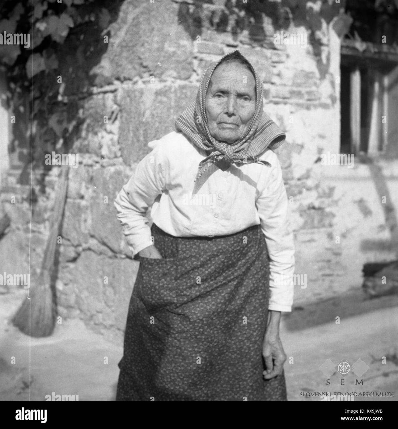 Photographie de 1957 de Julijana Koscicek, 85 ans, à Zuzemberk, Slovénie, vêtue d'une tenue blanche traditionnelle avec une chemise de nuit et un tablier, représentant les traditions et les vêtements culturels locaux. Banque D'Images