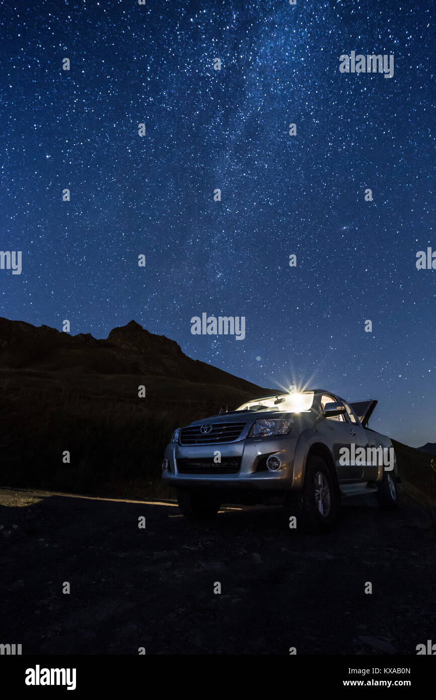 Quatre roues motrices pick up garé dans les Alpes durant la nuit avec voie lactée au-dessus de lui, Saint Bernard pass, Savoie, France Banque D'Images