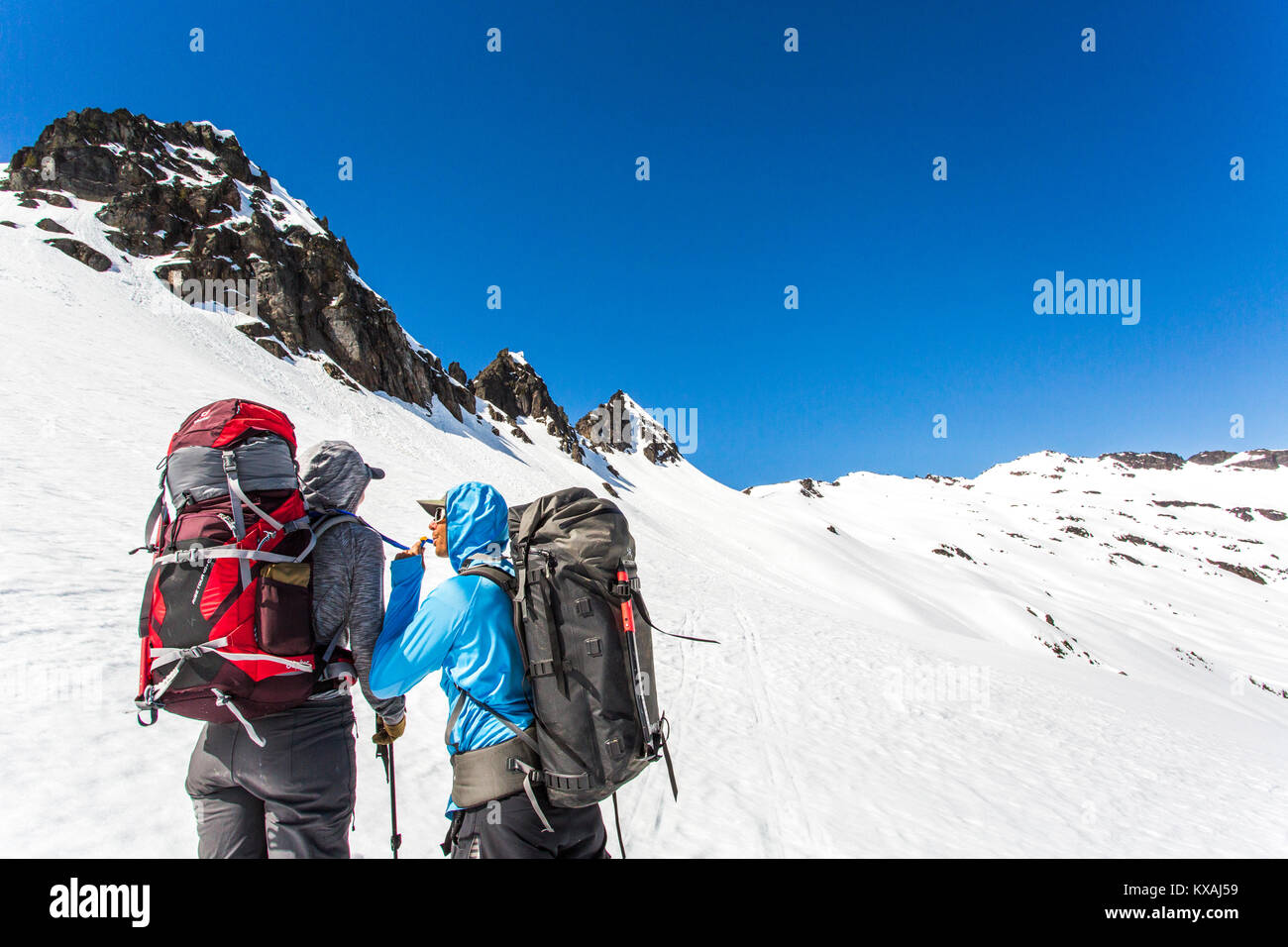 Skieur femelle boire d'hydration pack de partenaire masculin en traversant colline, Leavenworth, Kansas, USA Banque D'Images