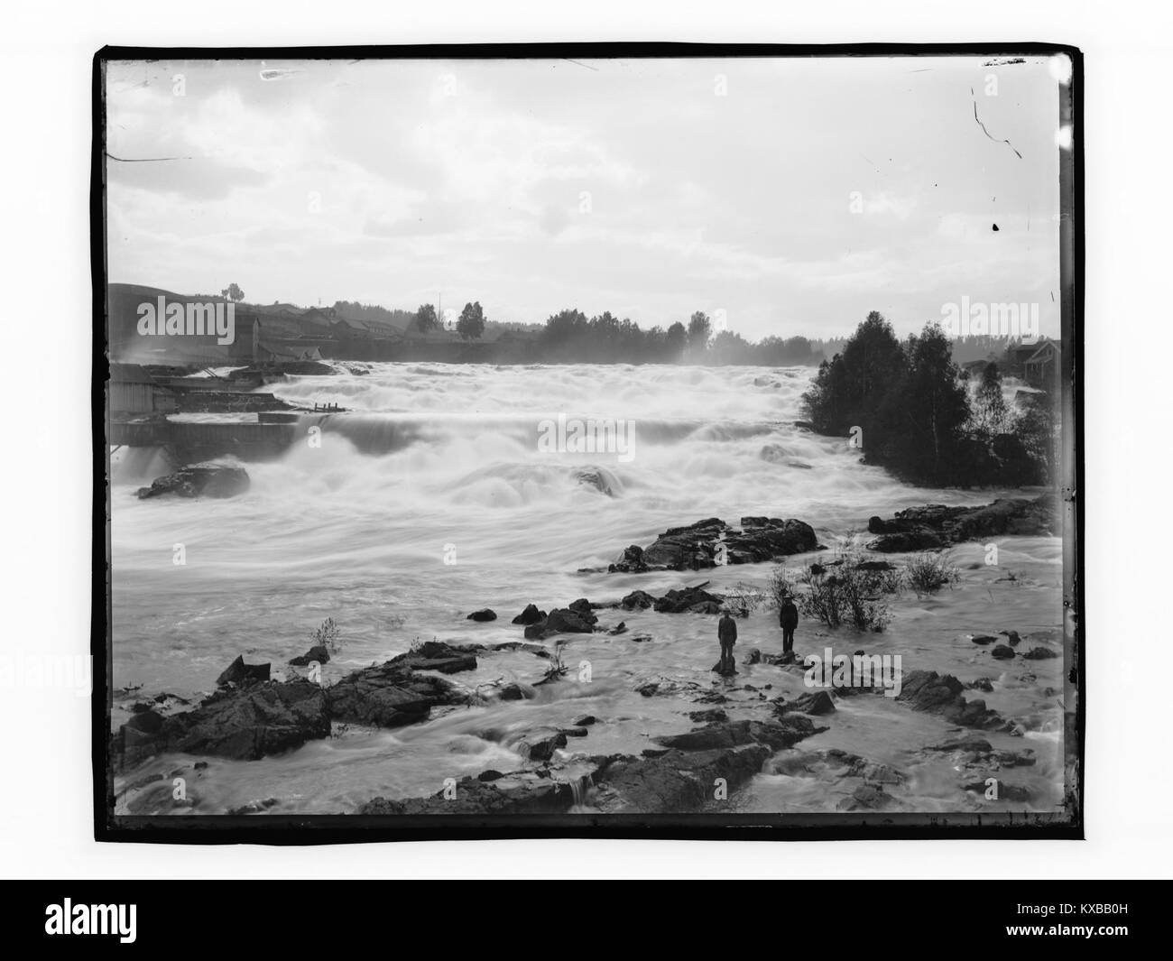 La cascade de Hønefoss avec les bâtiments environnants en Norvège est représentée, montrant l'interaction du paysage naturel avec les structures urbaines et les schémas de peuplement. Banque D'Images