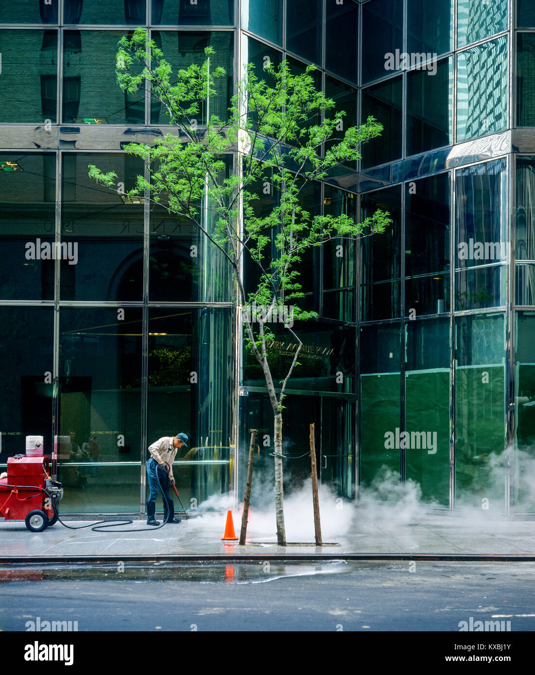 New York 1980s, ouvrier nettoyant la chaussée avec l'unité de jets d'eau haute pression, Park Avenue Plaza, Manhattan, New York City, NY, NYC, ETATS-UNIS, Banque D'Images