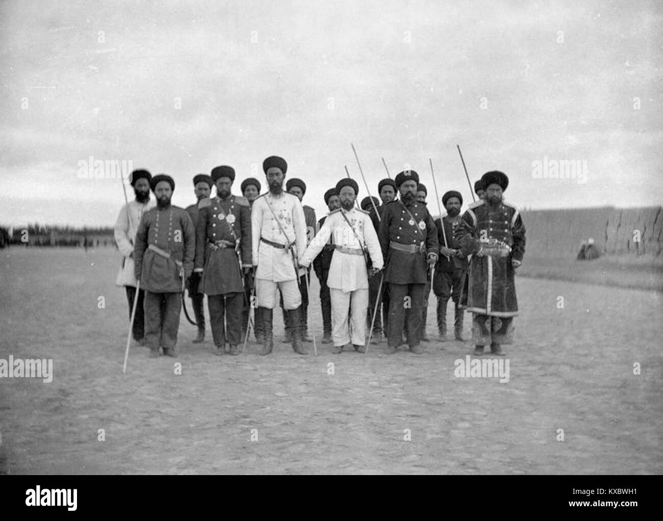 Revue militaire à Boukhara montrant des soldats alignés en formation avec des officiers inspectant les troupes, reflétant les pratiques militaires d'Asie centrale du début du XXe siècle. Banque D'Images