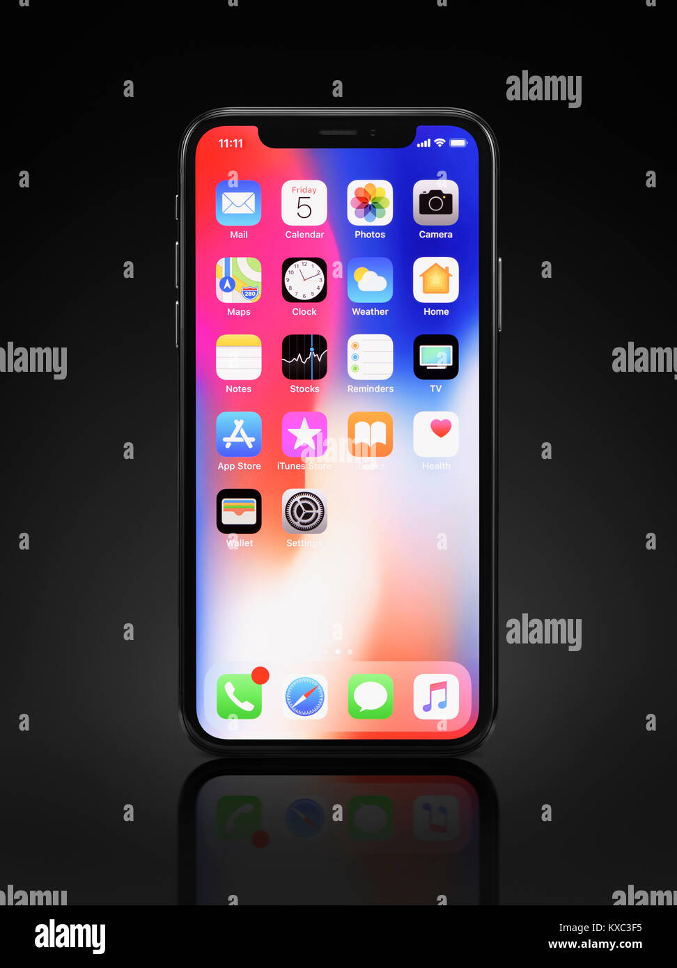 Apple iPhone x, grand écran smartphone, produit la vie encore avec les ordinateurs de bureau et les icônes d'applications sur son écran couleur bleu rouge debout isolé sur b Banque D'Images