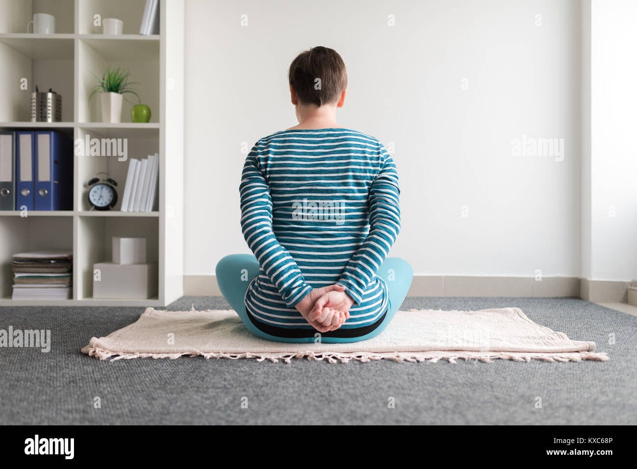 Pregnant woman practicing yoga exercice à la maison. Le yoga et la grossesse à l'intérieur concept de remise en forme. Images à faible contraste hors cadre naturel avec la lumière de la fenêtre. Banque D'Images