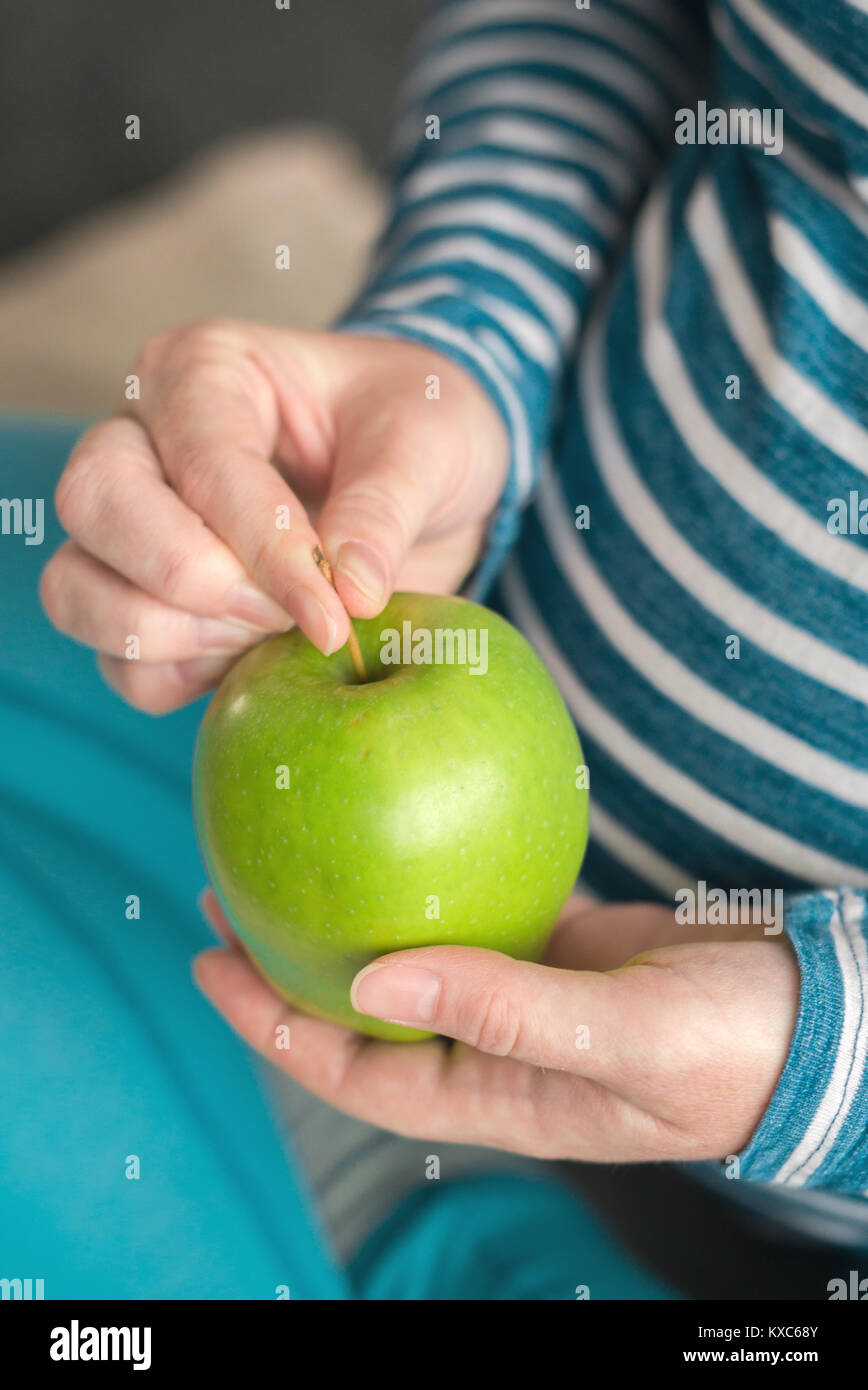 Pregnant woman holding green apple en tant que symbole de la santé Banque D'Images