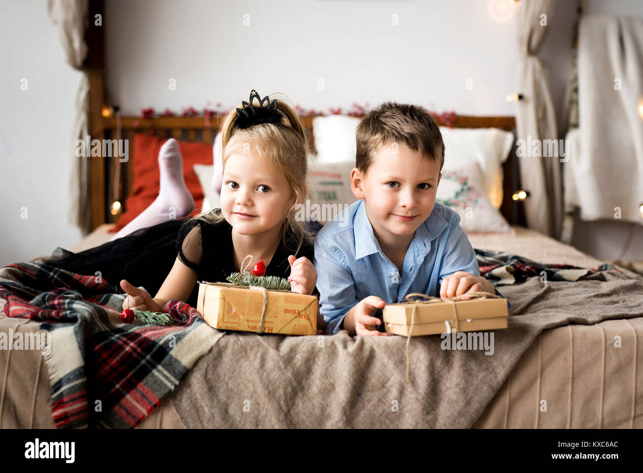 Jolie fille et garçon ouvrir les cadeaux. Joyeux Noël et de bonnes vacances. Banque D'Images