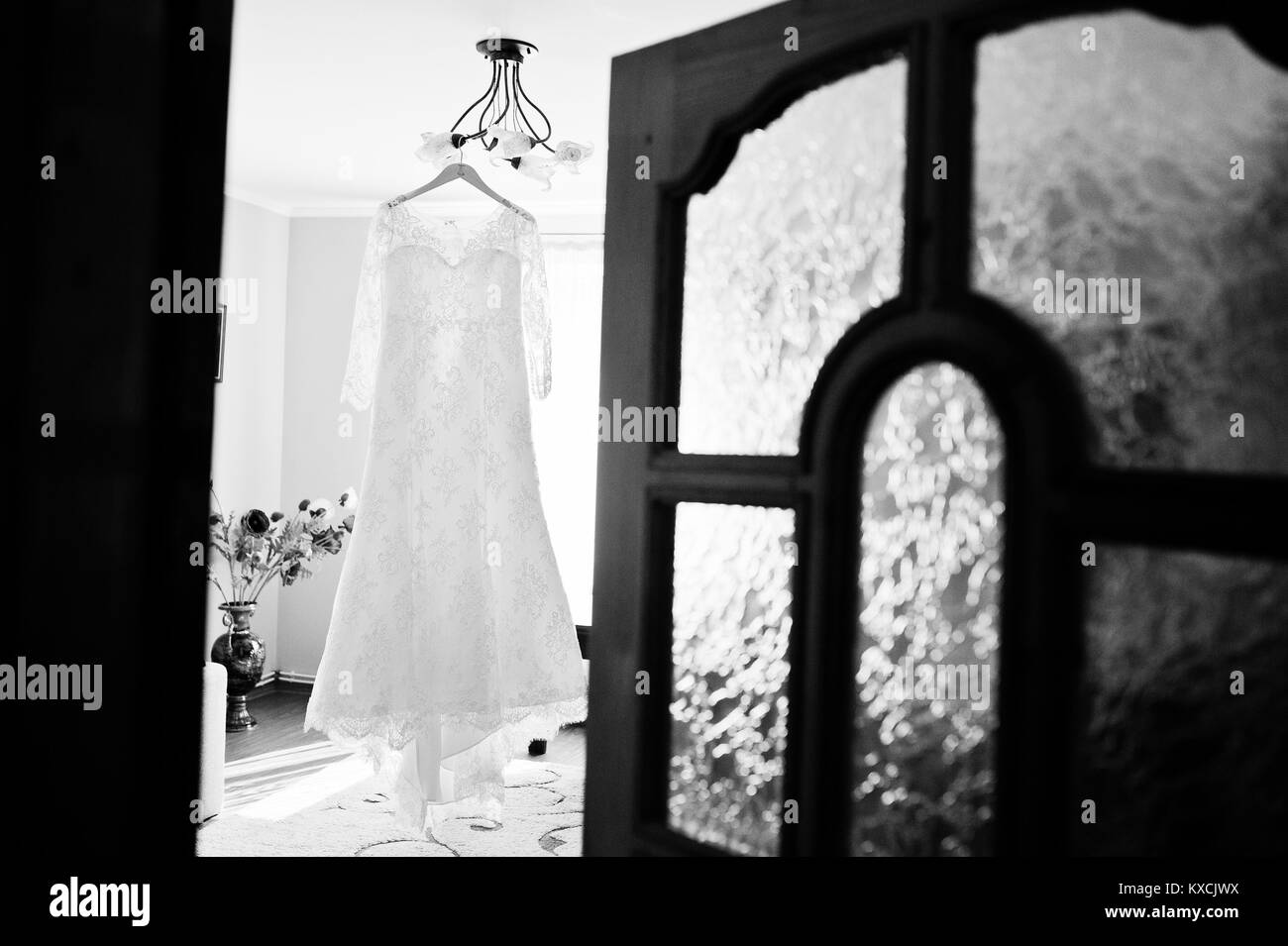 La robe de mariée mariée accroché sur le crochet dans la chambre. Photo en noir et blanc. Banque D'Images