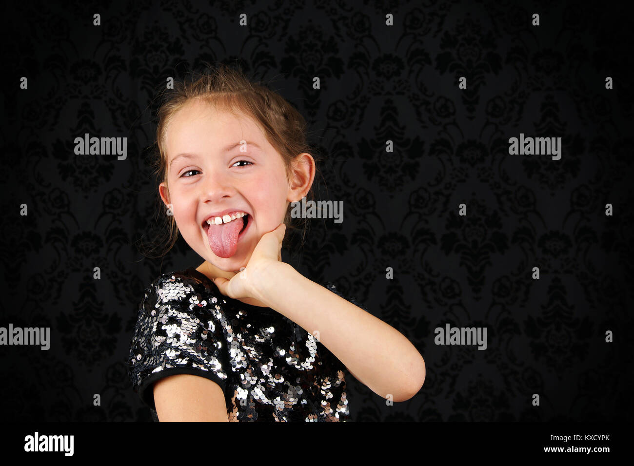 Portrait de drôle de petit blond girl sticking out tongue Banque D'Images