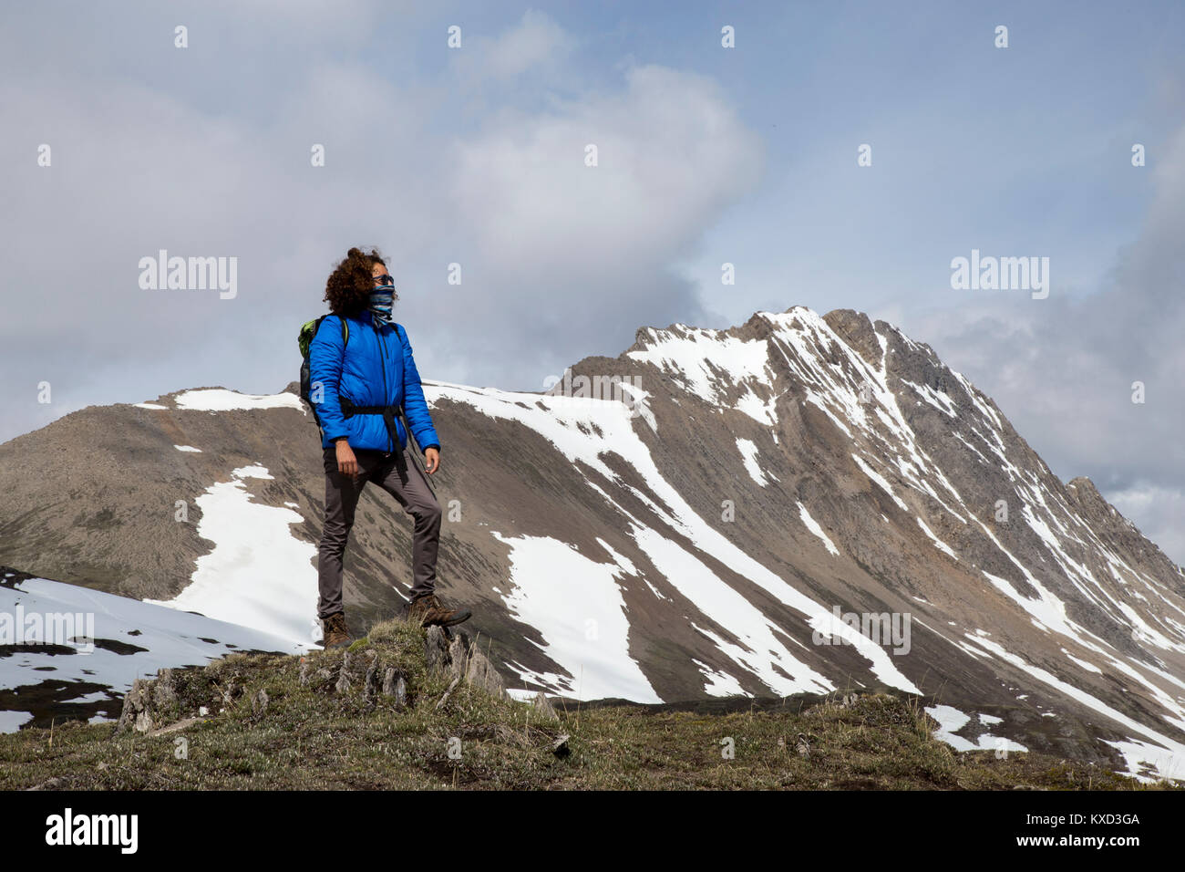 Toute la longueur du randonneur avec foulard couvrant la bouche à la vue à l'encontre de montagne Banque D'Images