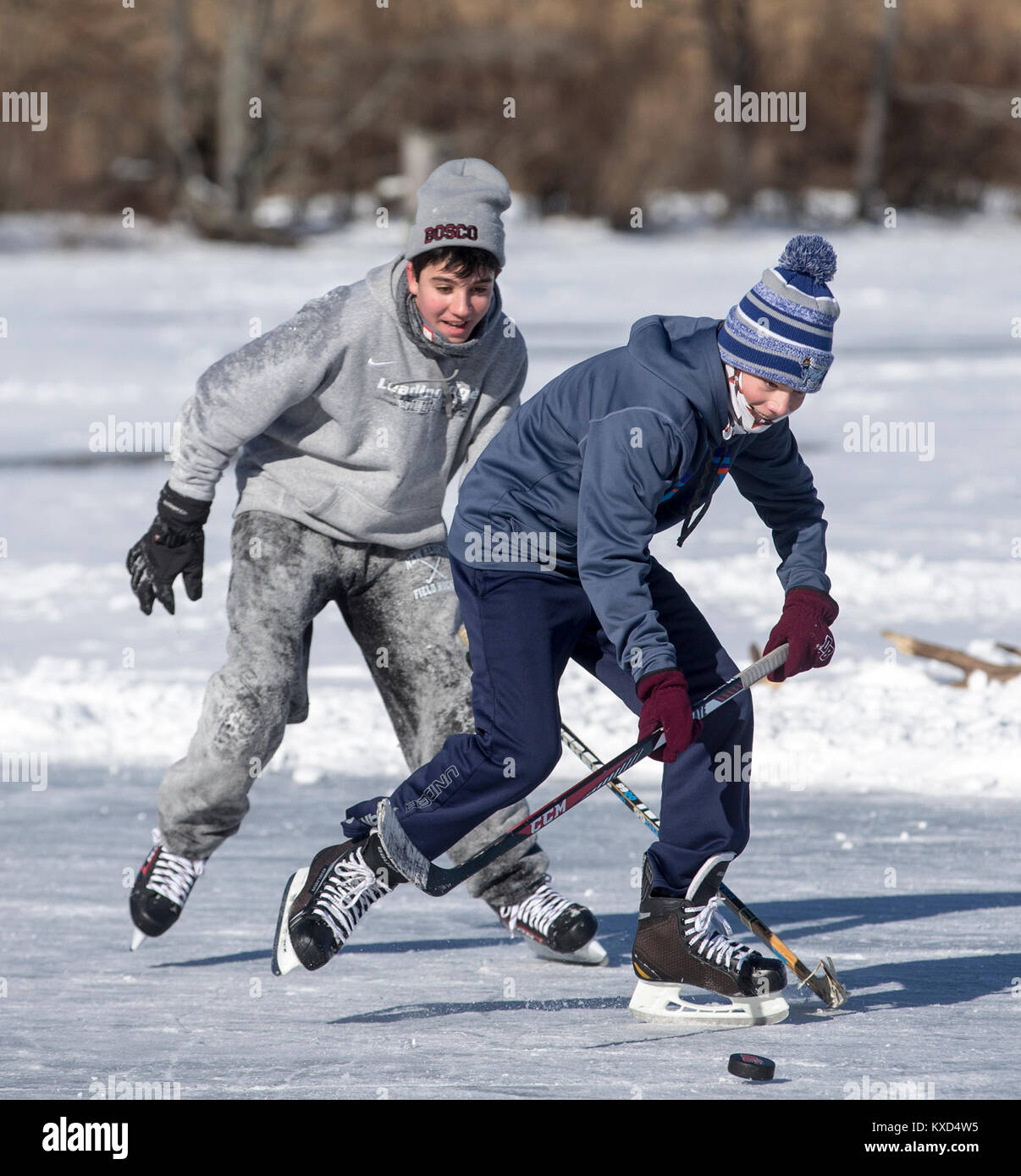 Jouer au hockey sur glace sur un étang sur une froide journée d'hiver Banque D'Images