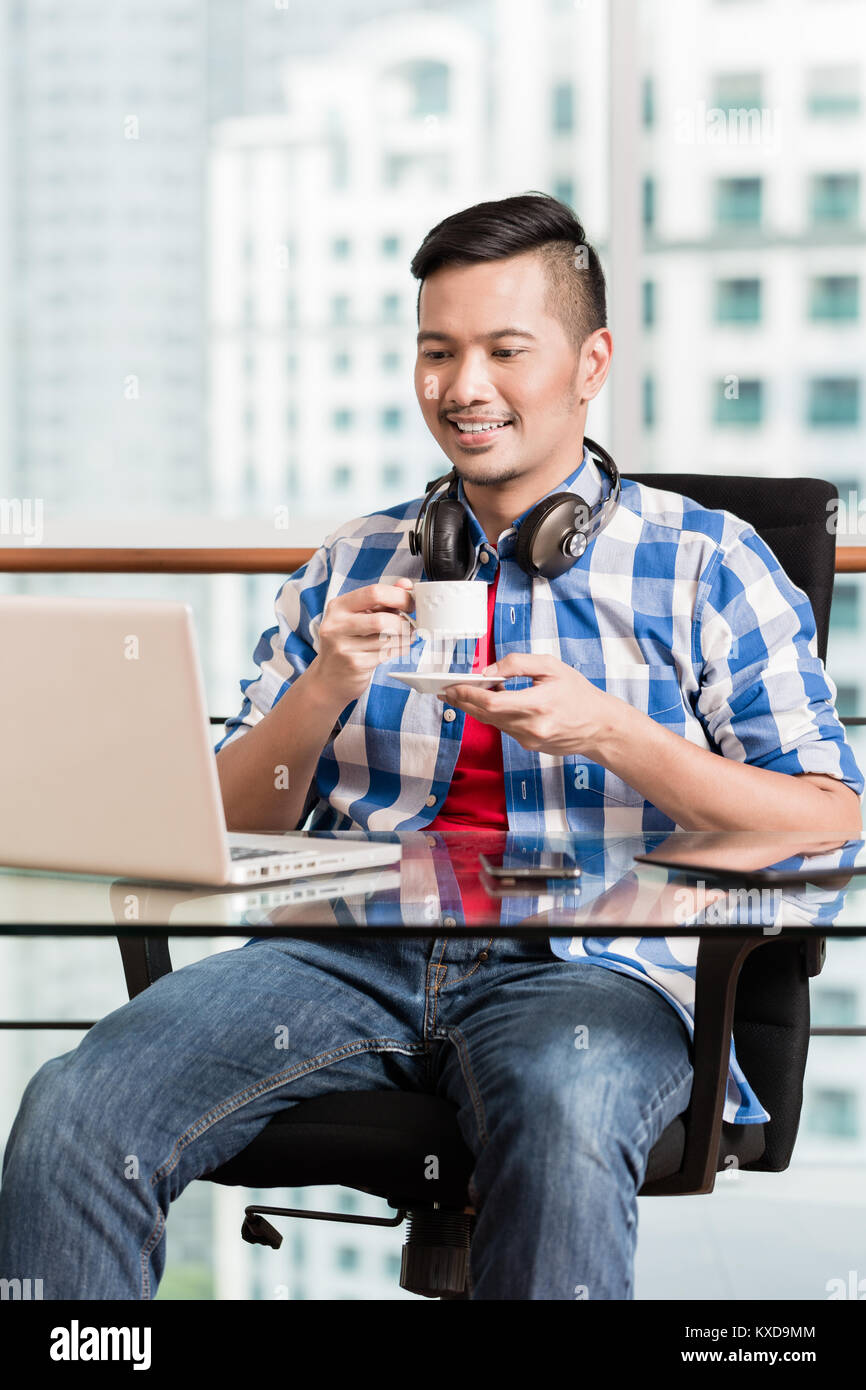 Professionnels Indonésiens travaillant sur ordinateur portable le café Banque D'Images