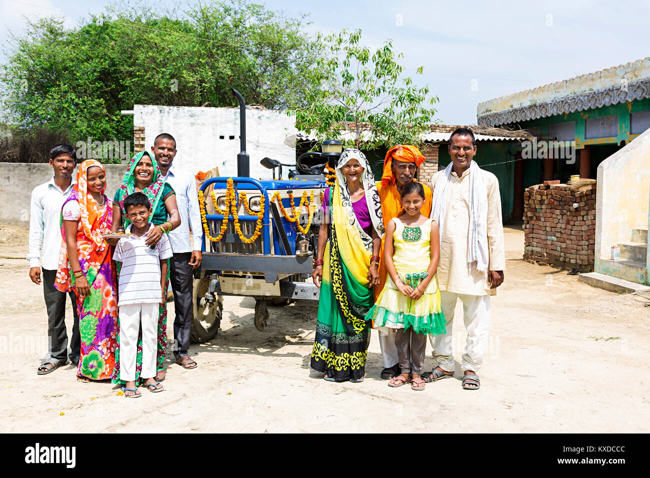 Les groupes indiens Farmer Grande Famille se tenant ensemble près de Village du tracteur Banque D'Images