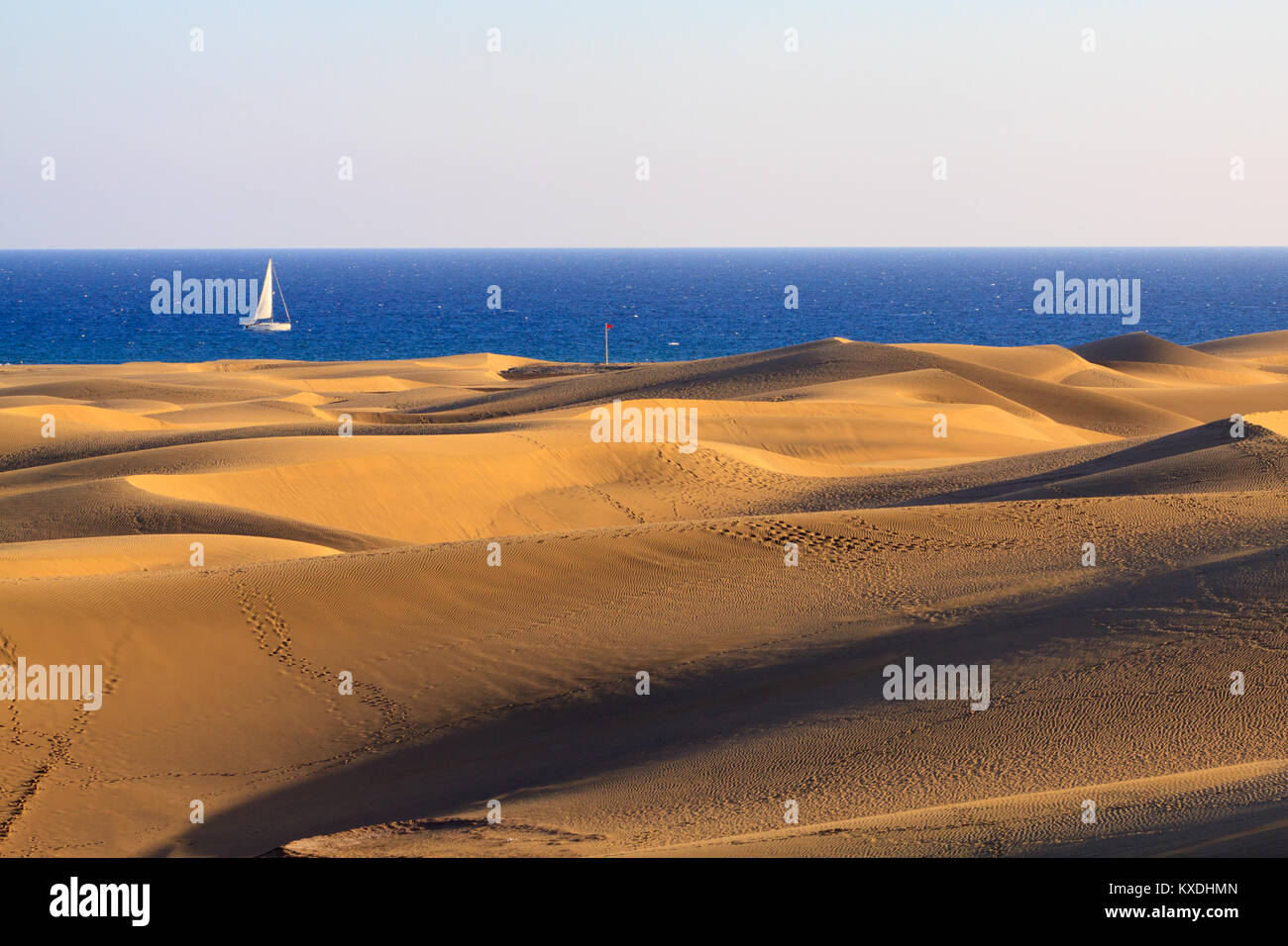 Dans les dunes de Maspalomas Gran Canaria island avec le voilier sur l'océan en arrière-plan. Banque D'Images