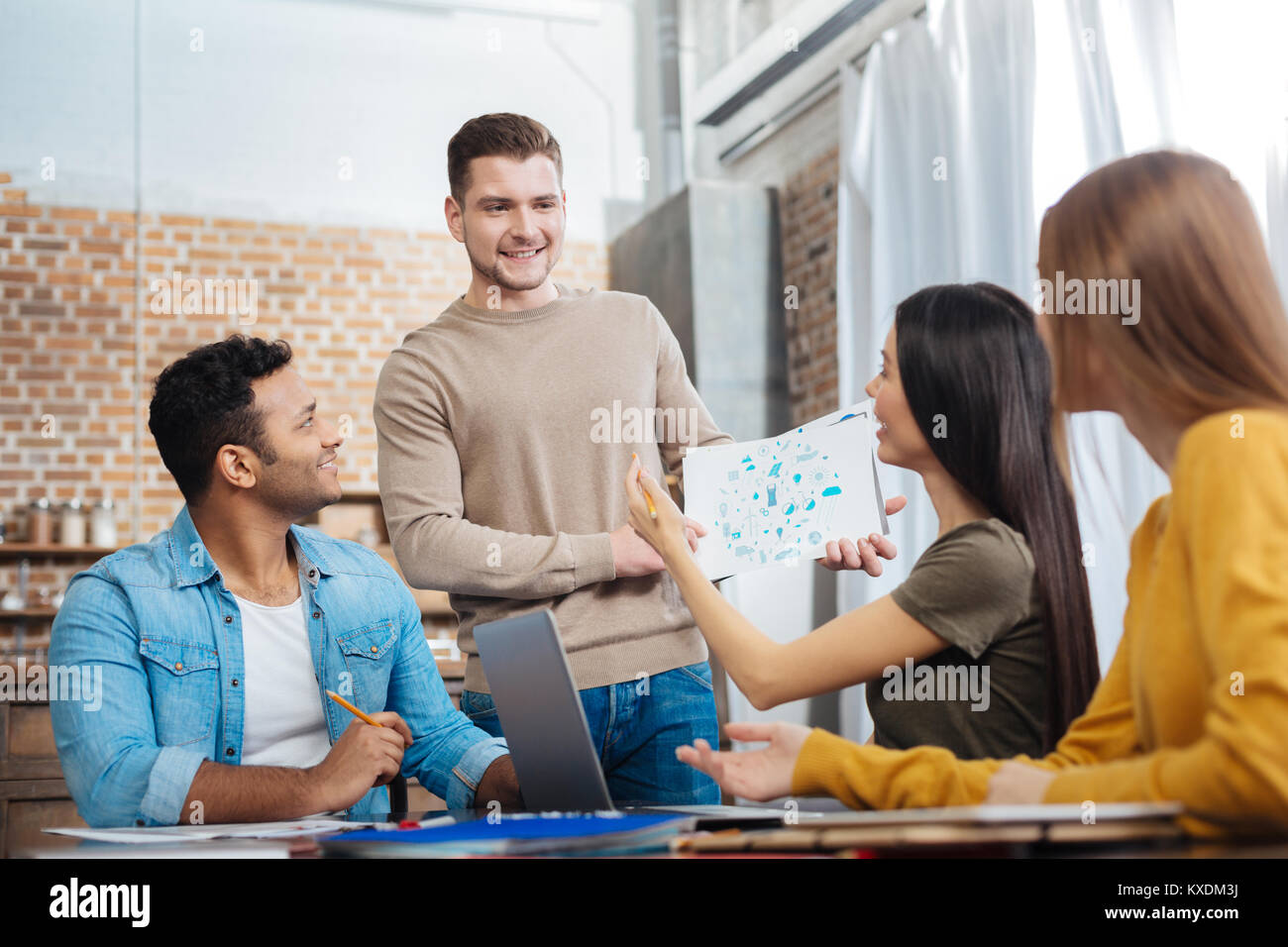 Joyeux émotionnel students smiling en regardant le projet de leur ami Banque D'Images