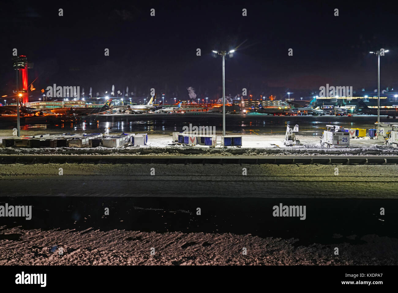 Vue de nuit sur les opérations de mess et les retards à la l'aéroport international John F. Kennedy (JFK) après la tempête de neige hivernale-cyclone bombe Grayson. Banque D'Images