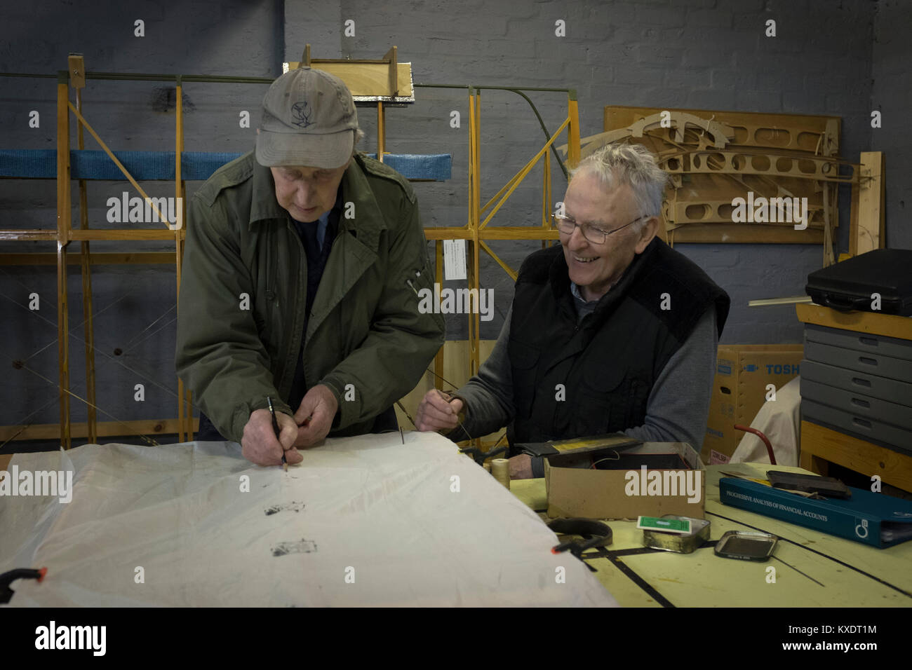 Les bénévoles John Guy (à droite) et Jim O'Donnell travaille sur une partie d'un Sopworth Strutter en construction par des membres de la Société de préservation de l'aviation de l'Écosse (APSS) lors d'un atelier sur le site du Musée de l'aviation à l'East Fortune, l'Écosse. Le projet de construction de la Première Guerre mondiale fighter a commencé il y a presque 15 ans et a impliqué des dizaines d'hommes de la construction des plans d'origine à l'aide d'un biplan. Chaque partie de l'aéronef a été individuellement conçue ou provenant d'assurer l'authenticité et l'on espère qu'il sera terminé et se transmettre par voie aérienne en 2016. Banque D'Images